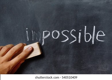  Hand Changing The Word Impossible To Possible. Alphabet I, M Being Erased From A Chalkboard. Change Concept.