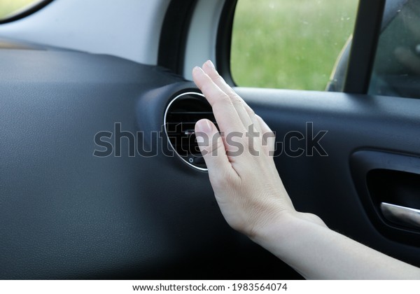 Hand checking the\
air conditioner in the car