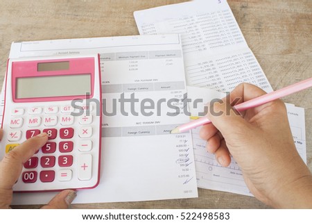 hand checking document monthly expense of credit card with passbook bank and payment slip of bank