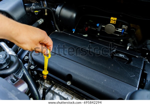The hand checks the oil\
in the engine