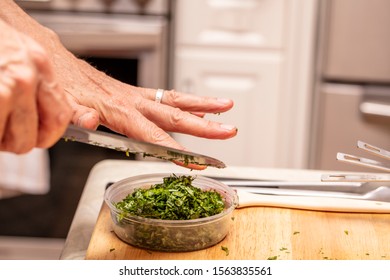 Hand Of A Chef Chopping Herbs As A Demonstration In A Food Preparation Class