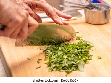 Hand Of A Chef Chopping Herbs As A Demonstration In A Food Preparation Class