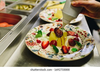 Hand Of Chef As He Or She Is Preparing A Salad In A Fancy Restaurant Kitchen