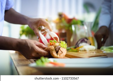 hand of chef holding french burger cooking and prepare in the kitchen in new and always fresh - Shutterstock ID 1102733567