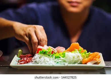 Hand Of Chef Making Sushi On Sushi Bar