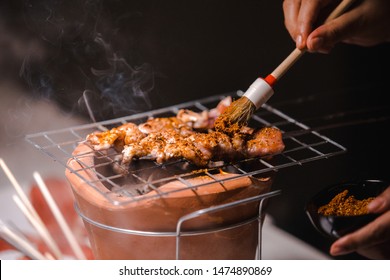 Hand Of Chef With Pork Grill Barbecue (ฺBBQ) With Seasonings Mala, Sichuan Pepper, Spices China Grilled On Charcoal Grill Stove, Black Background.