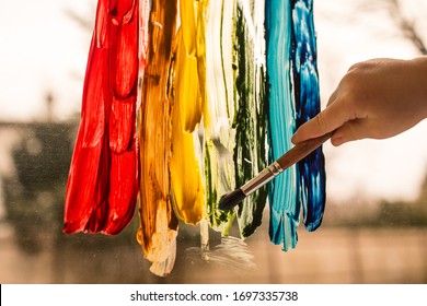 Hand Of Child Coloring Rainbow On Window, During Self Isolation, Covid Pandemic. Concept Of Hope And Dreams, 