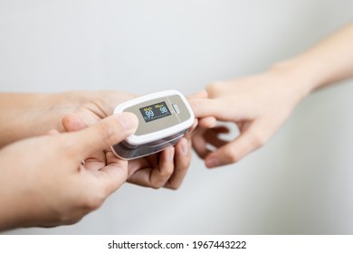 Hand Of Child Girl With Fingertip Pulse Oximeter On Finger For Examination Of The Lung Disease,checking For Coronavirus COVID-19 Infection From Oxygen Saturation At Home,measuring Heart Rate (pulse)