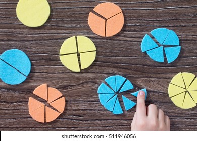 Hand of a child holds missing part of the puzzle in the study of mathematical fraction on a wooden table. Made with his own hands. The concept of early childhood development. - Shutterstock ID 511946056