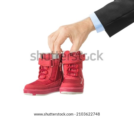 Hand with child shoes isolated on white background