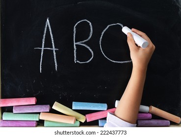 Hand Of Child Writing On Blackboard