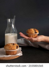 Hand With Chocolate Chips Muffins And A Jar Of Milk, Front View Dark Background Copy Space. Bakery Shop 