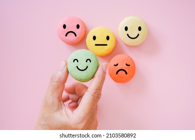 hand choose emotion face on green macarons ,good feedback rating and positive customer review, experience, satisfaction survey ,mental health assessment, child wellness, world mental health concept