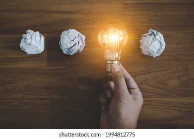 Hand choose light bulb and crumpled office paper. Concept of inspiration creative idea thinking and future technology innovation - Powered by Shutterstock