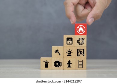 Hand Choose Wooden Block Stack With Fire Prevent Icon And Door Exit Sing Or Fire Escape With Fire Extinguisher And Emergency Protection Symbol For Safety And Rescue In The Building.