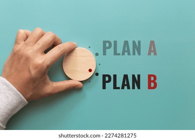 Hand choose wooden with the word PLAN A to PLAN B on green background. Business concept