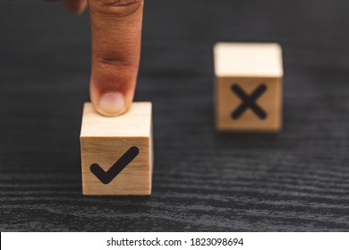 hand choose yes, true and blurred NO, false symbols on wood cube - True and false symbols accept rejected for evaluation - Shutterstock ID 1823098694