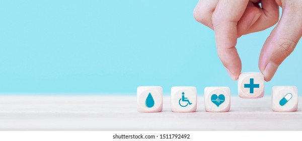 Hand chooses a emoticon icons healthcare medical symbol on wooden block , Healthcare and medical Insurance concept