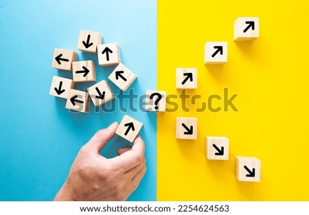 Hand choosing a block with arrows. Path leads to successful decision concept.