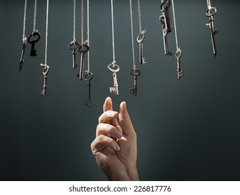 Hand choosing a hanging key amongst other ones.
