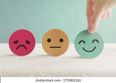 Hand choosing happy smile face paper cut, good feedback rating and positive customer review, experience, satisfaction survey ,mental health assessment, child wellness,world mental health day concept - Shutterstock ID 1735801265