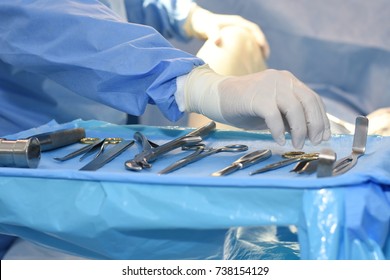 The surgeon’s hand is choosing the instruments of surgery in operating room.
