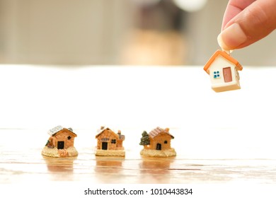 Hand Choosing Mini House Model. Planning To Purchase The Best Property.