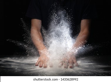 Hand Clap And White Flour On Black Background .