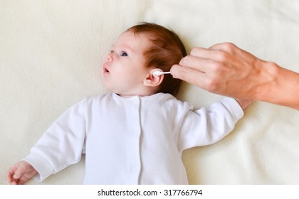 Hand Is Cleaning Baby's Ear