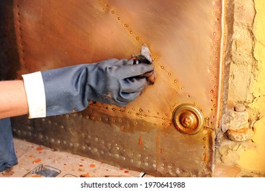 Hand Cleaning Of The Brass Lining Of An Old Wooden Door