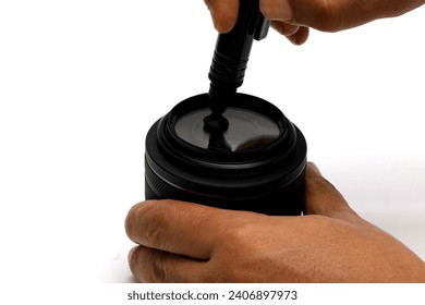 hand cleaning the camera lens with a lens cleaning tool. - Powered by Shutterstock