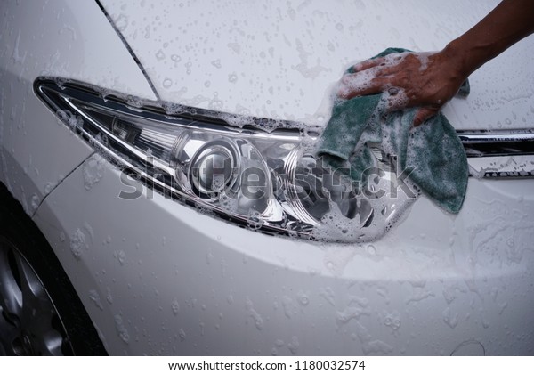 hand cleaning\
car headlight with rag outdoors\
4