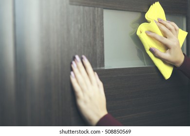 Hand Cleaning A Door With A Yellow Cloth