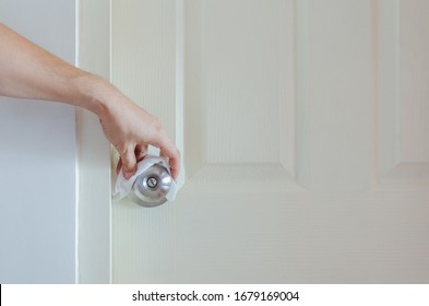 Hand Cleaning Doorknob With Alcohol To Protect Covid-19 Or Corona Virus Infection.