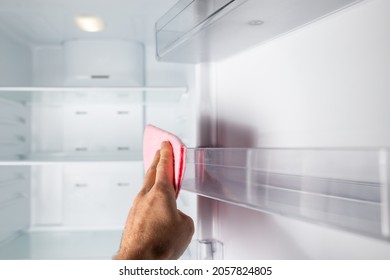 Hand Cleaning Empty Fridge Inside With Piece Of Cloth.