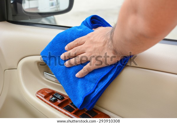 Hand cleaning interior car door panel with\
microfiber cloth