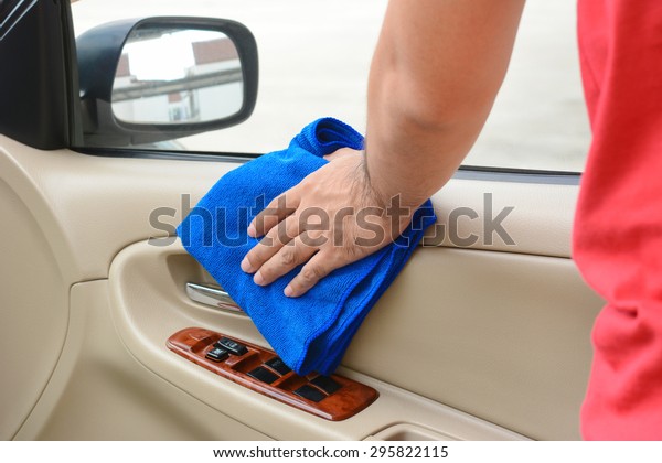 Hand cleaning interior car door panel with\
microfiber cloth