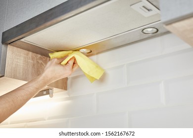 Hand Cleaning Kitchen Hood With Yellow Washcloth