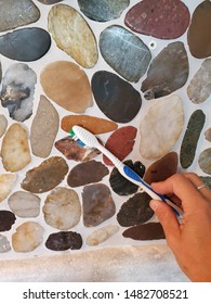 Hand Cleaning Rock Backsplash With Toothbrush