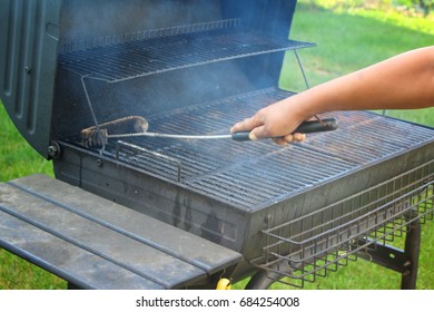 Hand Cleaning A Smoking Grill