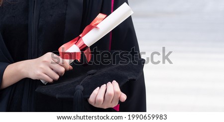 Hand of college student holding diploma or education degree in commencement day, concept of successful education, happy graduation, woman education equality, study abroad, overseas study scholarship