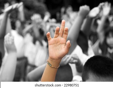 Hand In Color Raised Among Others Hands In Black And White Background