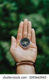 Hand With Compass Against Tropical Forest Jungle Terrain. POV Travel Concept