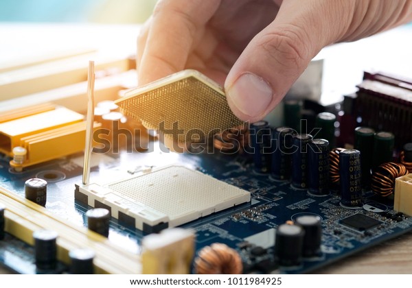 Hand of computer engineering brings\
computer cpu processor memory change components into socket\
processor for maintenance.Technology and development\
concept