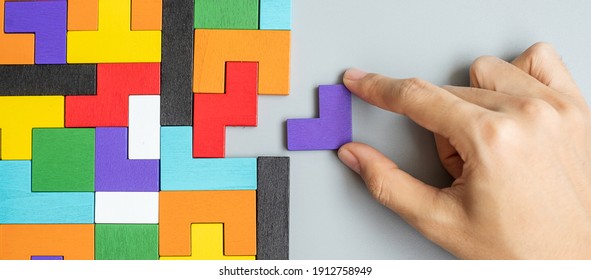 hand connecting geometric shape block with colorful wood puzzle pieces. logical thinking, business logic, Conundrum, decision, solutions, rational, mission, success, goals and strategy concepts - Shutterstock ID 1912758949