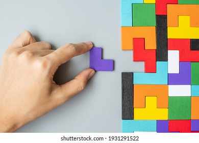 hand connecting geometric shape block with colorful wood puzzle pieces. logical thinking, business logic, Conundrum, decision, solutions, rational, mission, success, goals and strategy concepts - Shutterstock ID 1931291522