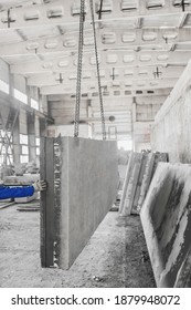 The Hand Of A Construction Worker Supports A Large Concrete Plate On A Hoist With A Chain In A Rebar Production Of An Industrial Enterprise