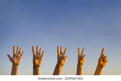 Hand countdown concept. Counting down on blue background. Gesturing number 5, 4, 3, 2, 1. Number five, four, three. two and one in sign language. Copy space for ad text. 