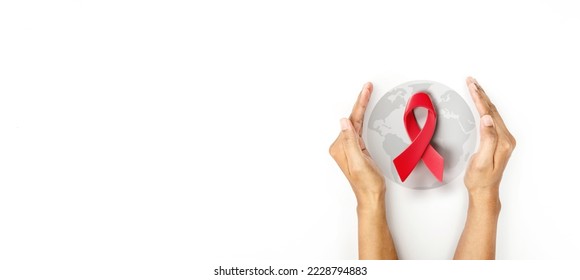 Hand covered 3d red ribbon on world map background, campaign for World AIDS Day on 1 December - Shutterstock ID 2228794883