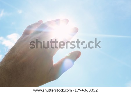 Hand covering the bright sun. Background. Texture.